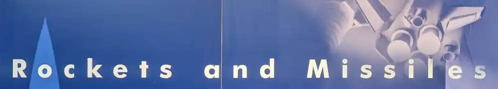 Two large exhibition display panels hung on a silver metal barrier system form a corner exhibition area. White text and graphics are shown on a dark blue background. A large case contains small rocket engines, models and components.