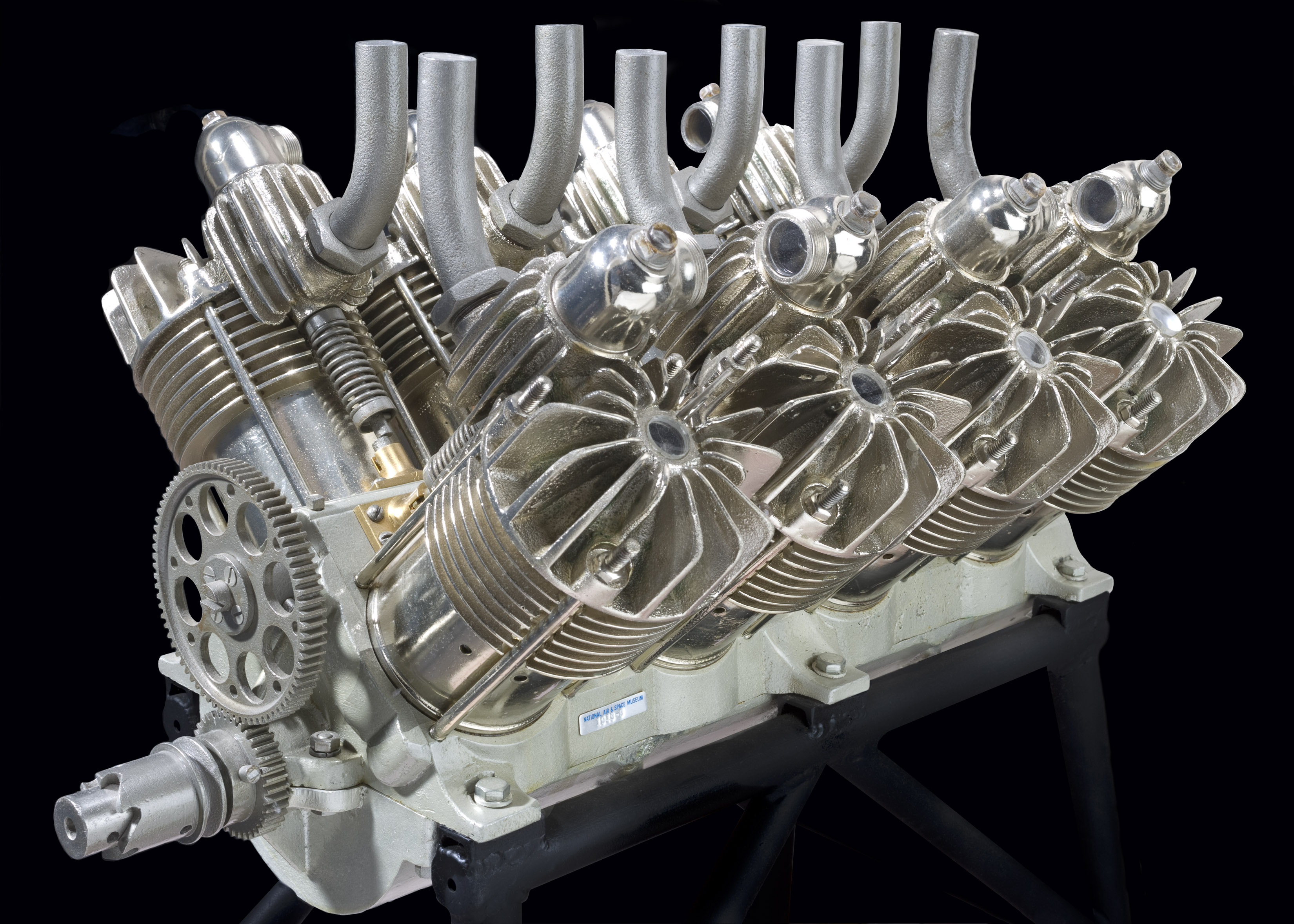An early V-8 engine with offset cylinder banks, exposed valves, crankcase, and air-cooled cylinders.