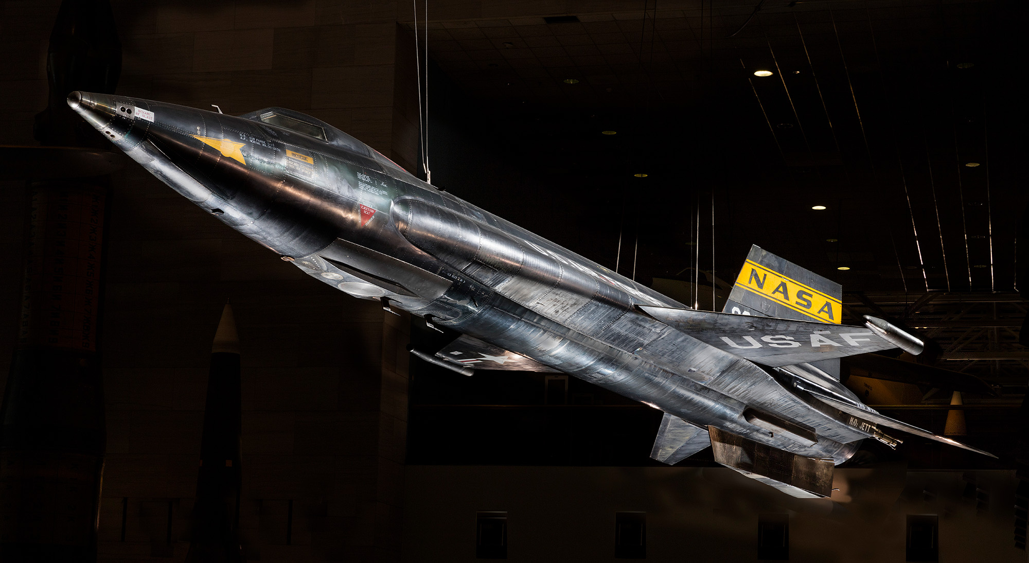 A large black rocket-powered research aircraft with a pointed nose, short wings, angular tail surfaces, NASA lettering, and U.S. Air Force markings.