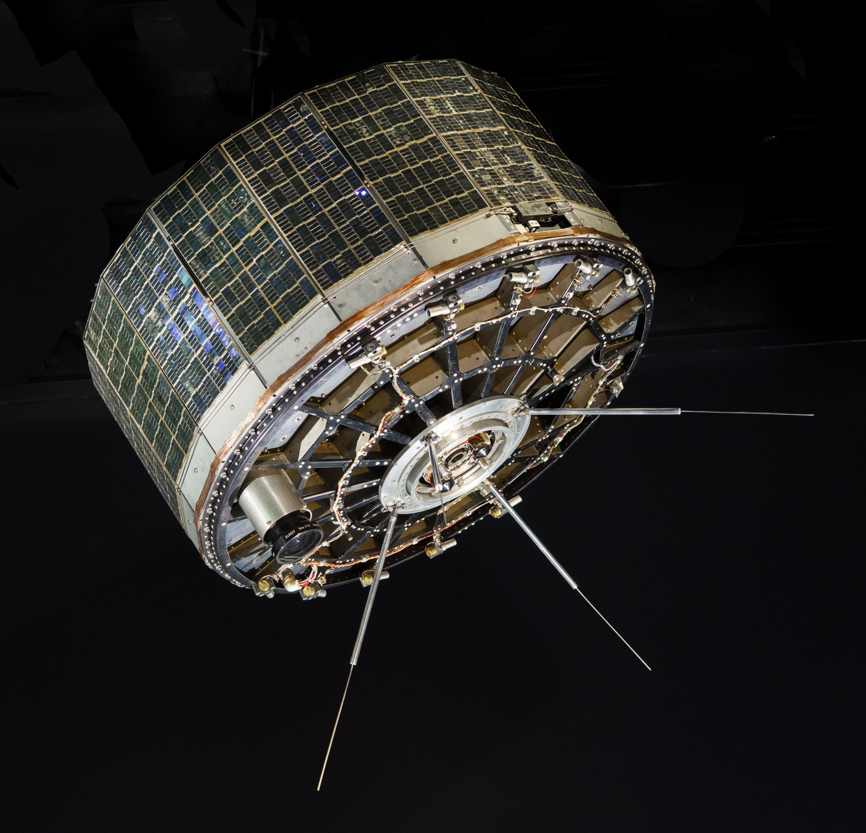 Short cylindrical weather satellite covered with solar cells and fitted with four rod antennas and two cameras.