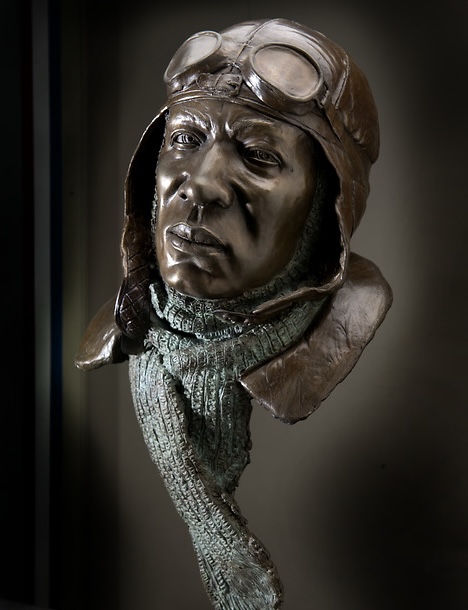 Sculpted bust of Eugene Bullard wearing an aviator cap, goggles, and scarf.