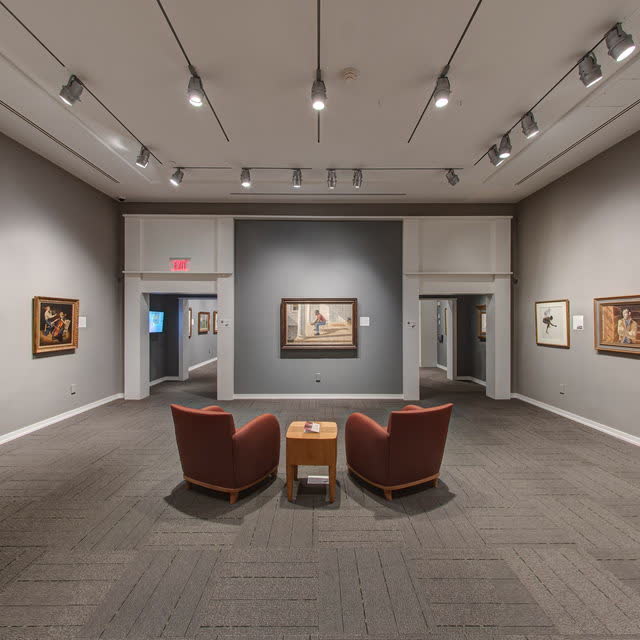 Quiet art gallery with two red chairs facing paintings at the Museum of the Shenandoah Valley